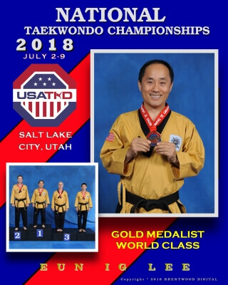 Torsoshot of Smiling Gold Medalist Master Lee during the 2018 US national Championship holding his medal